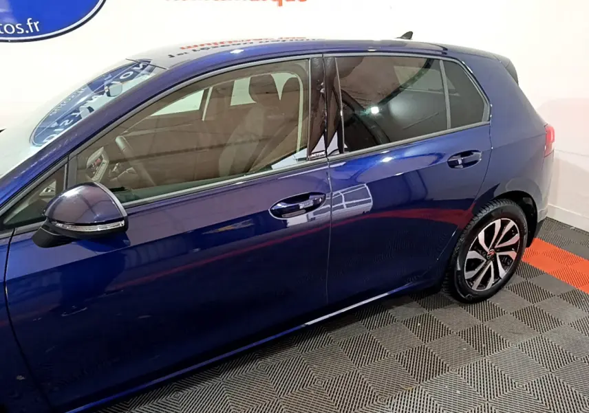 Profil côté gauche d'une Volkswagen Golf bleu 2022 avec jantes alliage et badge Active sur montant central.