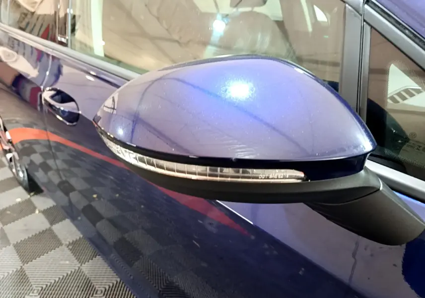 Rétroviseur droit bleu métallisé de la Volkswagen Golf 1.0 TSI 2022 avec clignotant intégré, vue rapprochée côté passager.