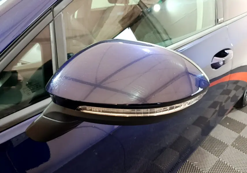 Rétroviseur côté gauche bleu brillant de la Volkswagen Golf 1.0 TSI 2022 avec clignotant intégré, vue rapprochée.