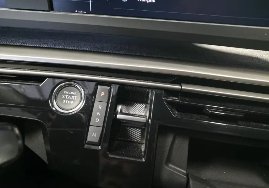 Gros plan sur la console centrale noire laquée du Peugeot 3008 2025 avec bouton start/stop et commandes de boîte auto.