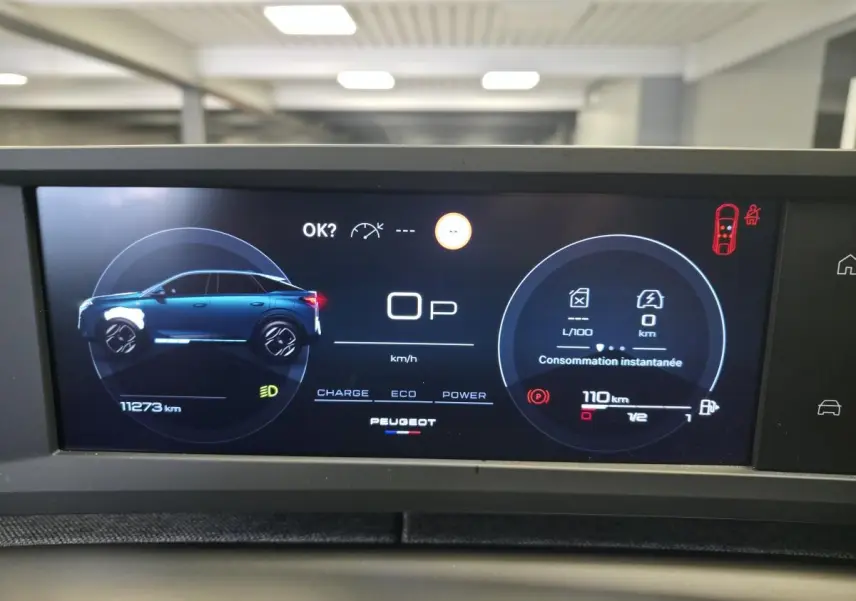 Affichage numérique du tableau de bord du Peugeot 3008 hybride, montrant la silhouette latérale bleue du véhicule et les données de consommation.