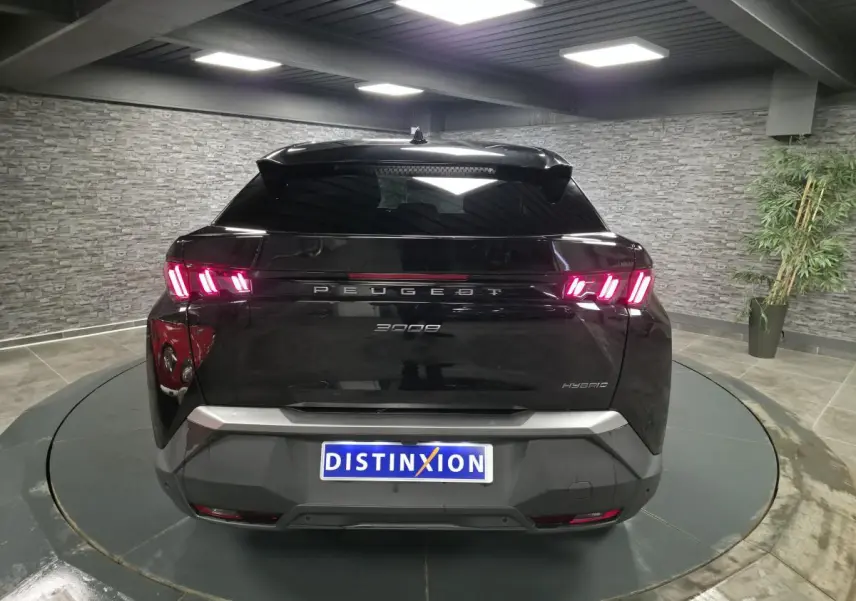 Vue arrière d’un Peugeot 3008 noir hybride 2025 avec feux arrière LED en forme de griffes et bandeau noir laqué.
