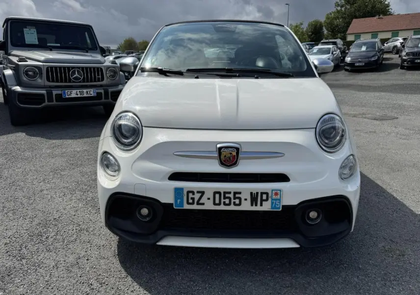 Vue frontale d'une ABARTH 500 blanche avec logo Abarth sur la calandre et phares ronds LED visibles.