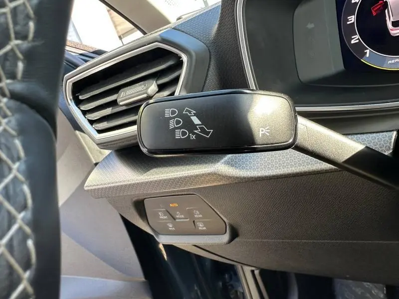 Détail du commodo des feux sur le côté gauche du tableau de bord d’un SEAT LEON ST 2025 bleu saphir métallisé.