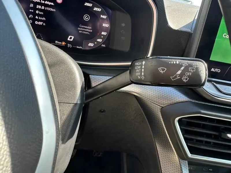 Gros plan sur la commande d’essuie-glace à gauche du volant dans l’habitacle d’une SEAT LEON ST bleu saphir 2025.