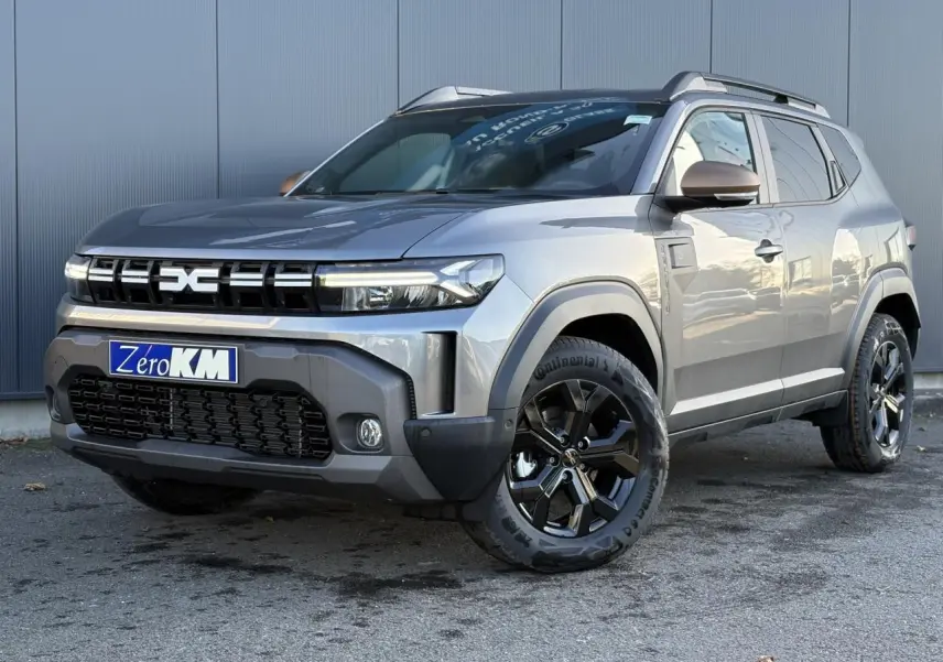 SUV Dacia Duster ECO-G 120 gris schiste en 3/4 avant droit, avec jantes alliage noires et barres de toit.