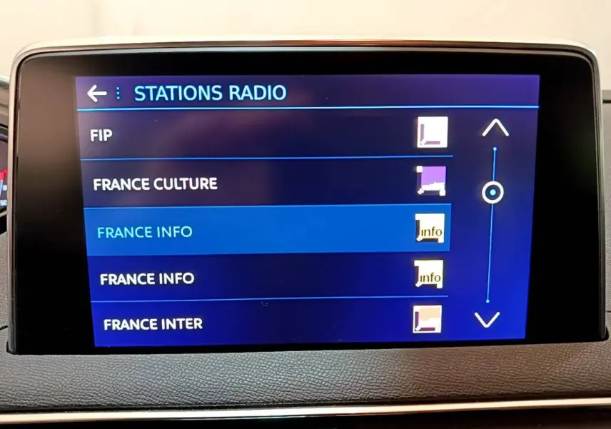 Écran tactile central affichant la liste des stations radio dans l'habitacle d'un Peugeot 3008 blanc.
