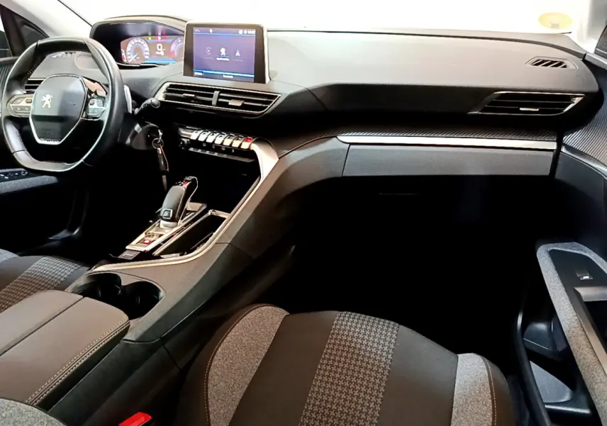 Intérieur du Peugeot 3008 2020 vu côté passager, tableau de bord moderne avec écran tactile et volant cuir noir.