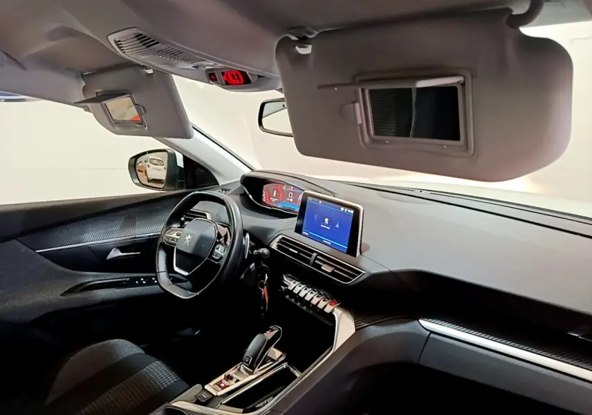 Intérieur du Peugeot 3008 blanc vu côté conducteur, tableau de bord moderne avec écran tactile et volant cuir multifonctions.