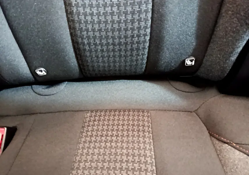 Gros plan sur la banquette arrière tissu gris du Peugeot 3008, avec fixations Isofix visibles sur les côtés.