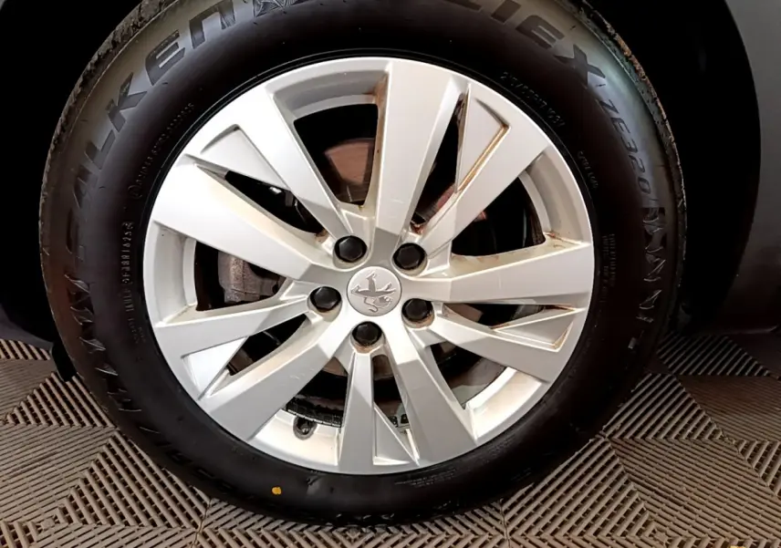 Gros plan sur la roue avant gauche d'un Peugeot 3008 blanc, avec jante alliage et pneu Falken visible.