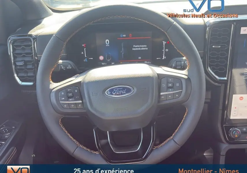 Vue rapprochée du volant multifonctions du Ford Ranger 2025, mettant en valeur les commandes intégrées et l'écran digital derrière.