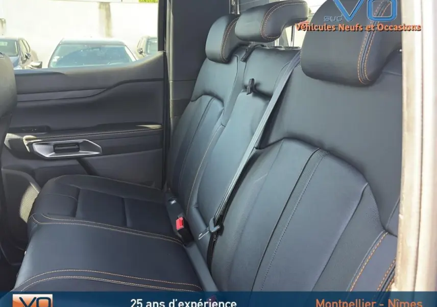 Vue intérieure du siège arrière en cuir noir avec surpiqûres orange du Ford Ranger Wildtrak 2025 double cabine.