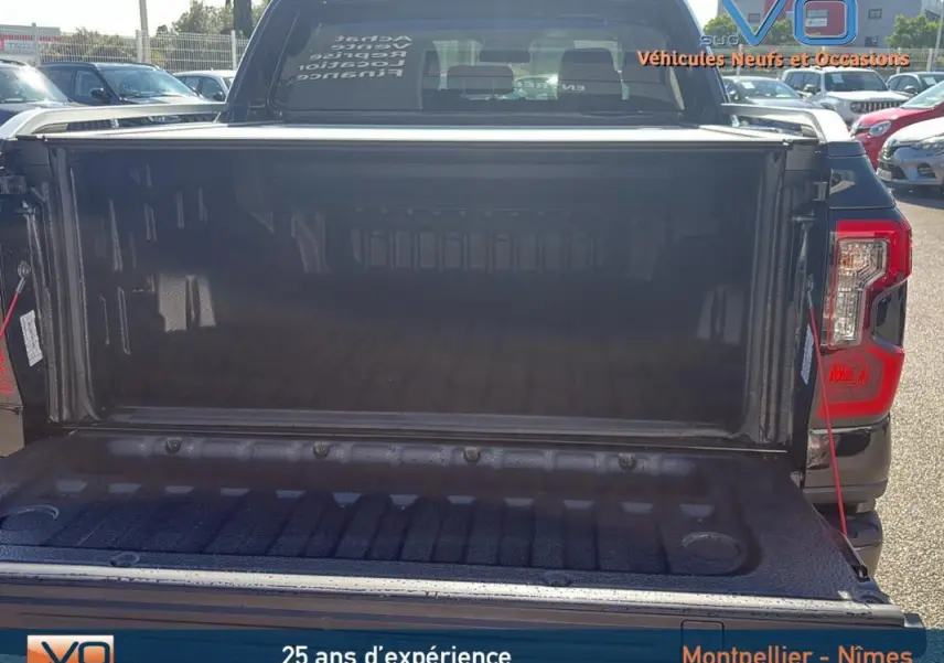 Vue arrière du Ford Ranger noir 2025 avec benne ouverte, feux arrière visibles et hayon abaissé.