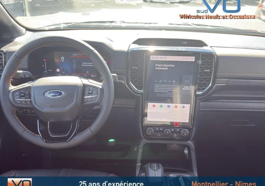 Intérieur du Ford Ranger 2025 avec volant multifonctions, grand écran tactile vertical et sellerie noire visible de face.