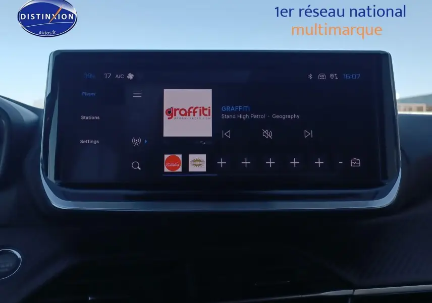 Écran tactile central du tableau de bord de la Peugeot 2008 gris Artense, affichant une radio numérique.