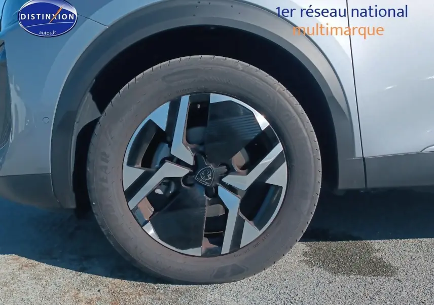Gros plan sur la roue avant gauche du Peugeot 2008 gris artense, mettant en valeur la jante alu au design moderne.