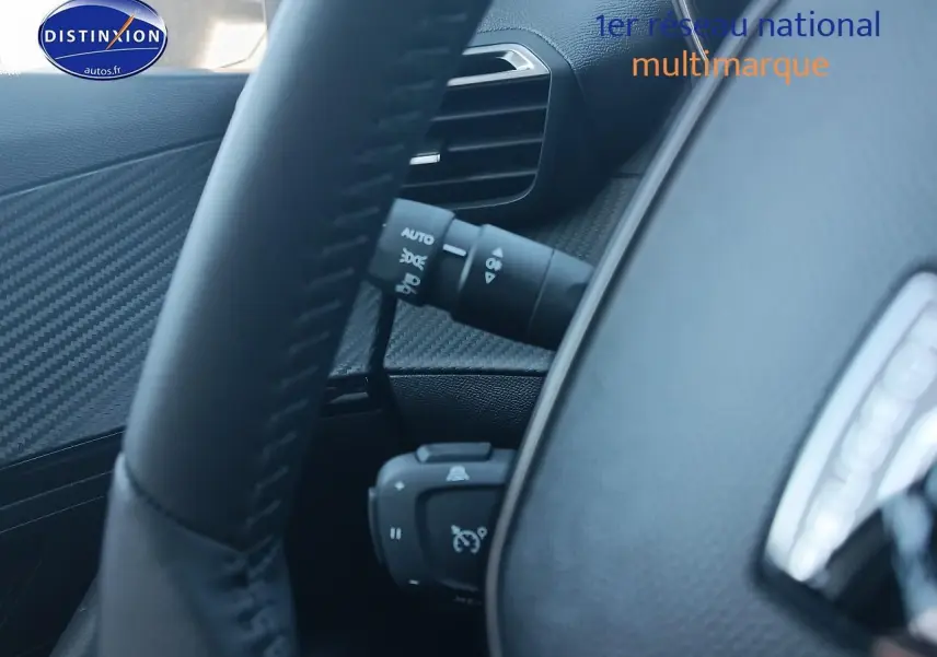 Gros plan sur le volant et la commande de régulateur de vitesse du Peugeot 2008 gris artense, intérieur noir.