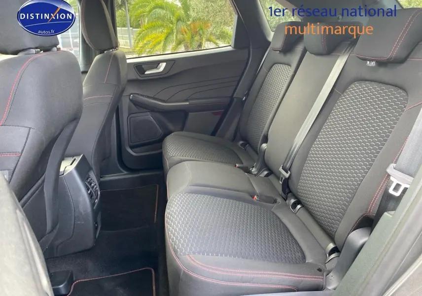 Vue intérieure des sièges arrière du Ford Kuga 2025 avec tissu noir et surpiqûres rouges, côté droit ouvert.
