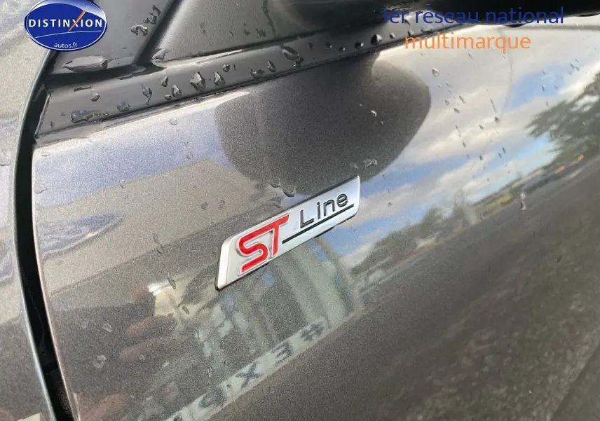 Gros plan sur l’écusson ST-Line sur la porte côté gauche d’un Ford Kuga gris Magnetic Fashion métallisé.