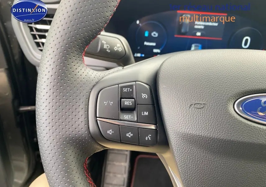 Gros plan sur le volant perforé avec commandes multifonctions du Ford Kuga 2025 gris Magnetic Fashion.