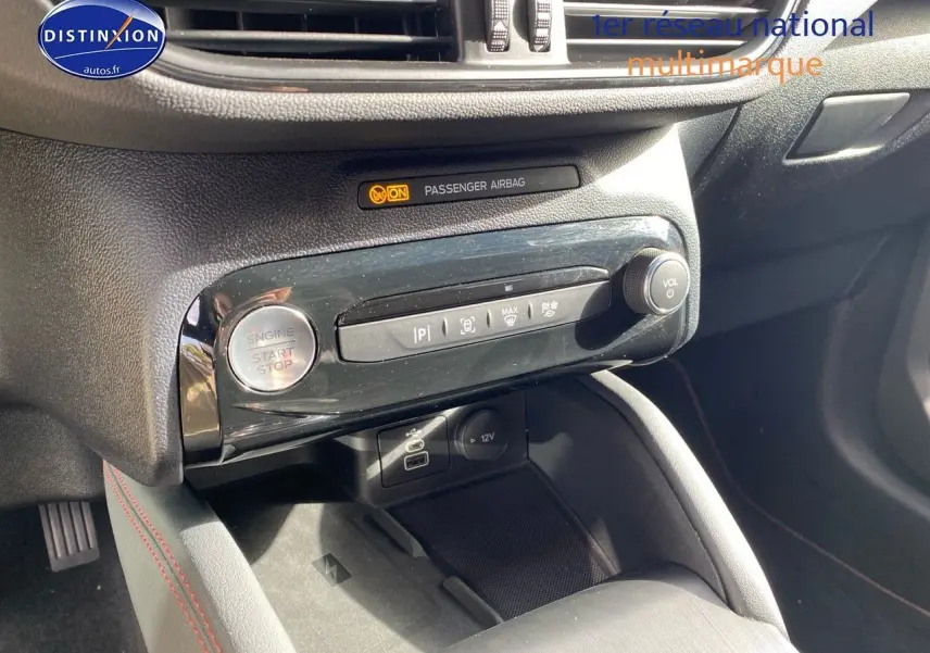 Détail de la console centrale noire du Ford Kuga 2025 avec bouton start/stop et commandes multimédia visibles.