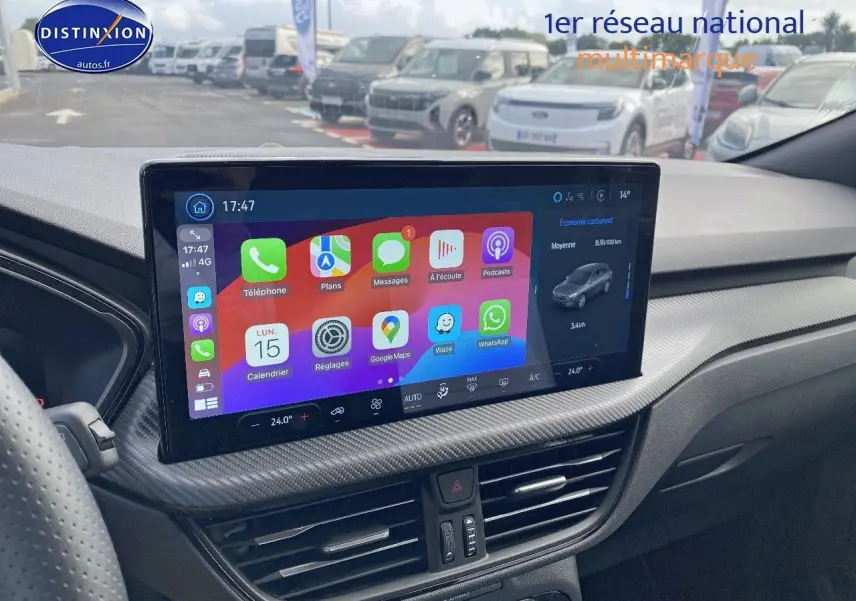 Vue intérieure du tableau de bord du Ford Kuga 2025 avec écran tactile central affichant des applications colorées.