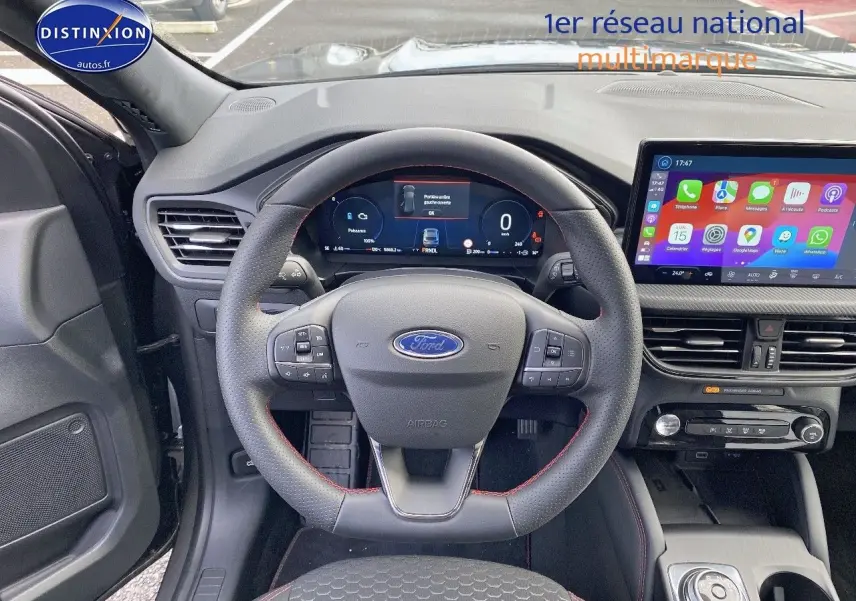 Vue intérieure centrée sur le volant Ford Kuga 2025 avec tableau de bord numérique et écran tactile couleur.