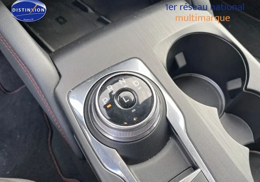 Gros plan sur la molette de sélection de la boîte automatique du Ford Kuga 2025, entourée de console grise et porte-gobelets.