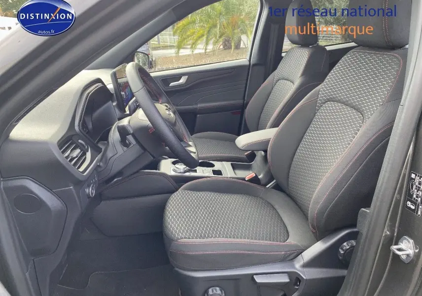 Vue intérieure côté conducteur du Ford Kuga 2025 gris Magnetic, sièges tissu ST-Line avec surpiqûres rouges.