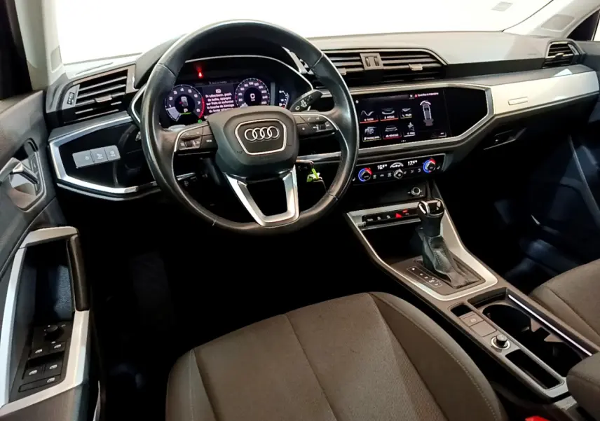 Vue intérieure de l'Audi Q3 Sportback 35 TFSI 150 MHEV 2021, tableau de bord et volant cuir noir multifonctions.