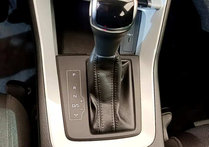 Le levier de vitesses automatique noir de l'Audi Q3 Sportback 35 TFSI 150 MHEV vu de dessus, entouré de console grise.