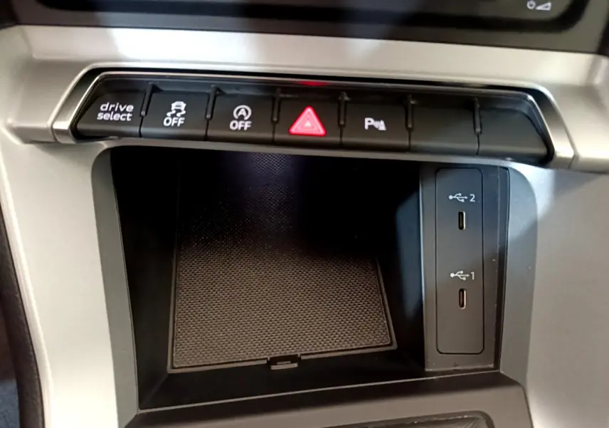 Gros plan sur la console centrale de l'Audi Q3 Sportback 35 TFSI 150 MHEV 2021, montrant les boutons de contrôle et ports USB.