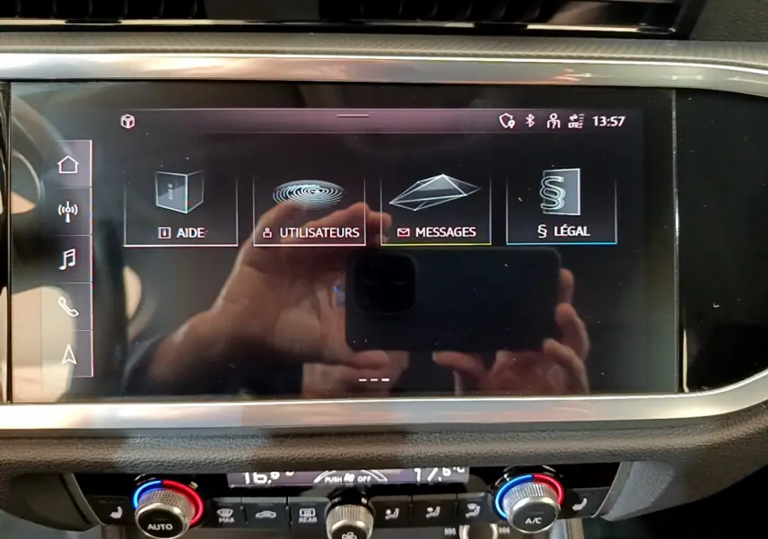 Écran tactile central affichant les menus d’aide et messages dans l’Audi Q3 Sportback noir, vue intérieure frontale.
