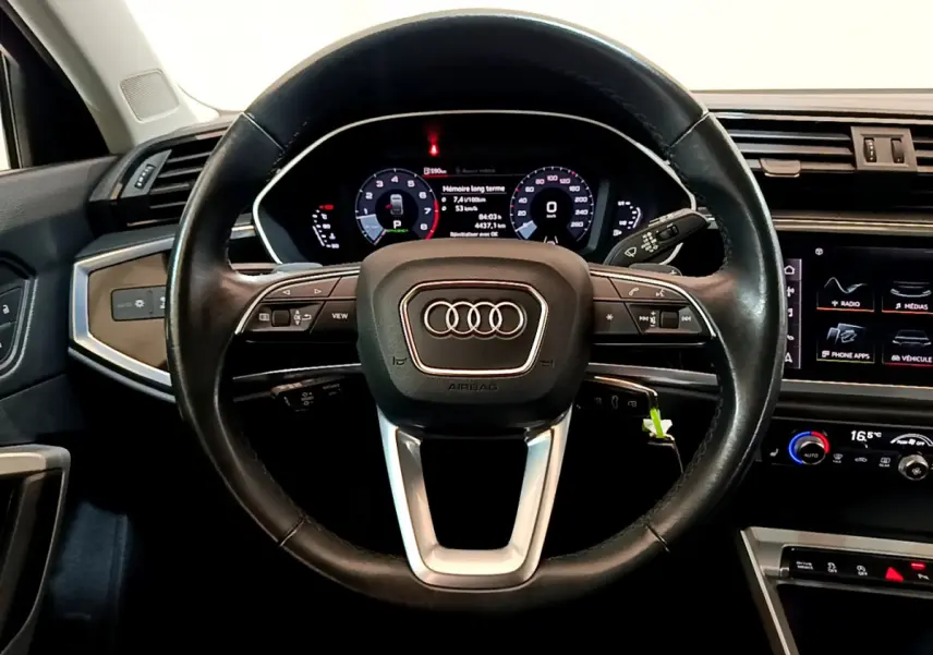 Volant cuir noir de l'Audi Q3 Sportback 35 TFSI 150 MHEV 2021 vu de face avec tableau de bord numérique et commandes intégrées.