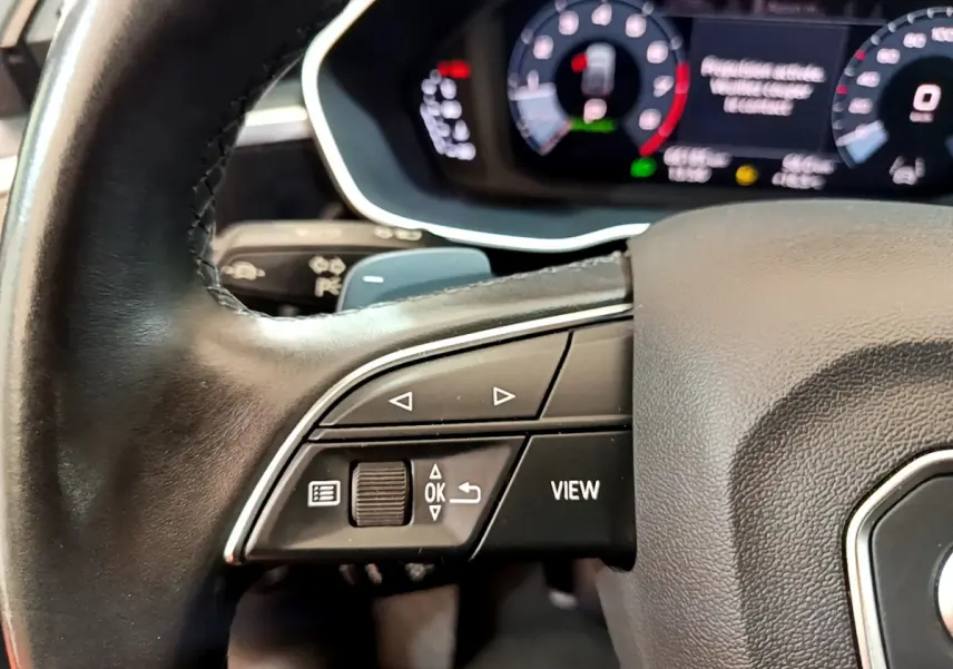 Gros plan sur le volant cuir noir de l'Audi Q3 Sportback 2021 avec commandes multifonctions et tableau de bord numérique.