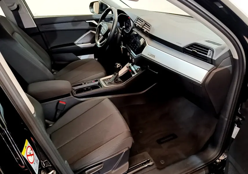 Intérieur noir de l'Audi Q3 Sportback 35 TFSI 2021, vue côté conducteur avec tableau de bord moderne et volant cuir.