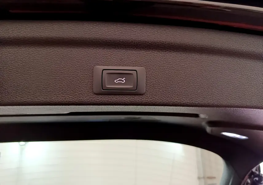 Bouton d'ouverture électrique du coffre sur le bord intérieur du hayon d'un Audi Q3 Sportback noir 2021.