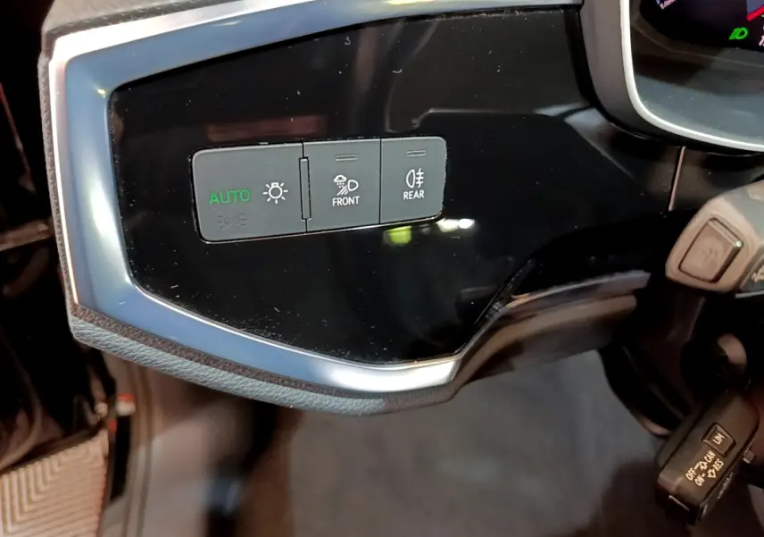 Gros plan sur les commandes d'éclairage noires et grises du tableau de bord côté gauche de l'Audi Q3 Sportback noir 2021.