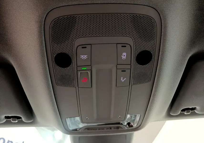 Vue en contre-plongée du panneau de commandes au plafond de l'Audi Q3 Sportback noir, avec boutons d'éclairage et appel d'urgence.