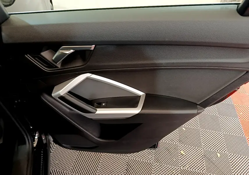Gros plan sur la porte côté gauche noire de l'Audi Q3 Sportback 35 TFSI 150 MHEV avec poignée argentée.