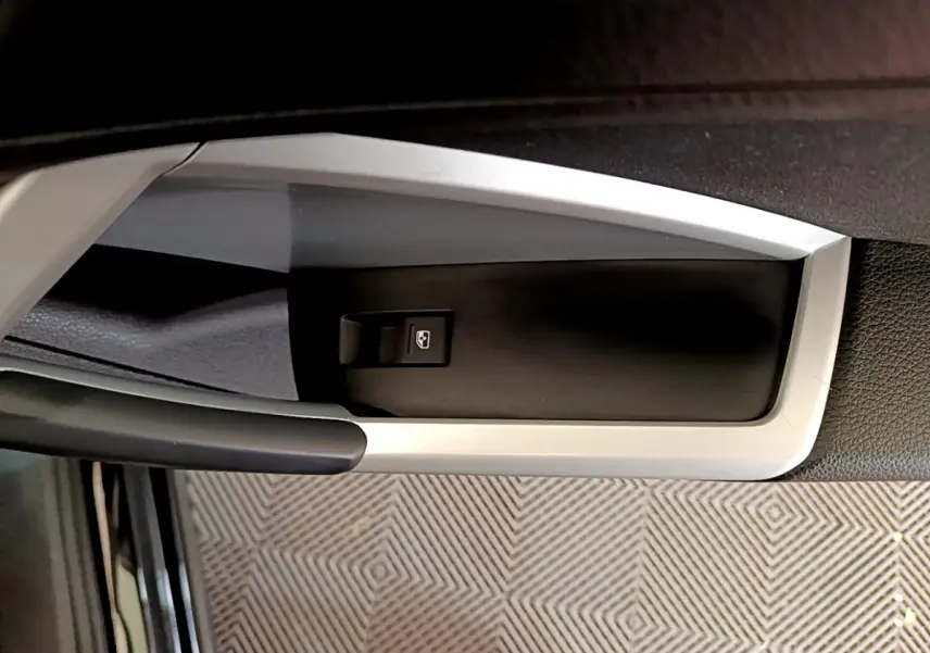 Gros plan sur la commande de lève-vitre côté conducteur dans l'habitacle noir de l'Audi Q3 Sportback 2021.
