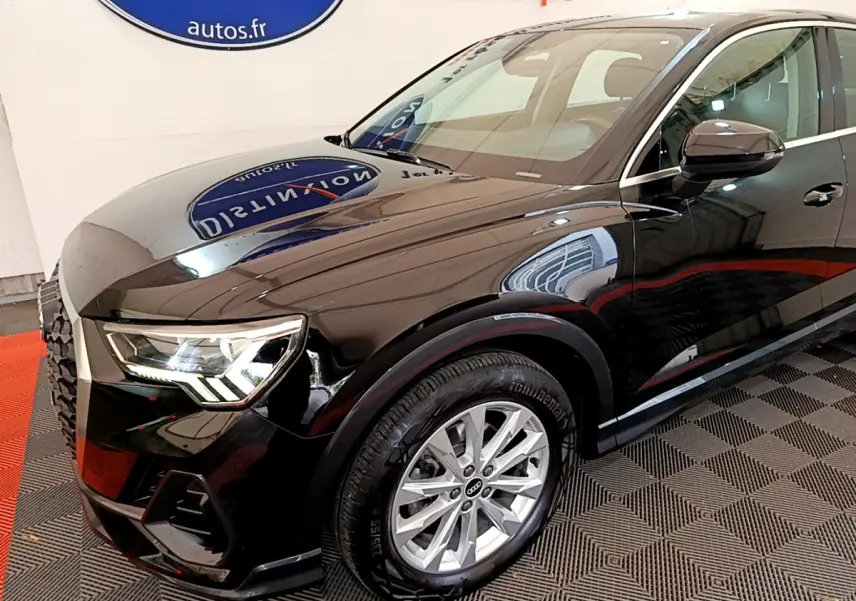 Vue 3/4 avant gauche d'un Audi Q3 Sportback noir brillant avec phares LED et jantes argentées.