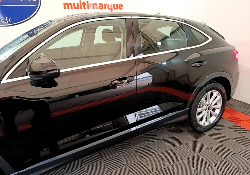 Profil côté gauche d'un Audi Q3 Sportback noir 2021, mettant en valeur ses lignes dynamiques et ses jantes alliage.