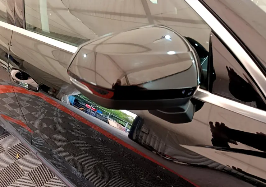 Rétroviseur côté gauche noir brillant de l'Audi Q3 Sportback 35 TFSI 150 MHEV S Tronic 7, reflet de l'environnement visible.