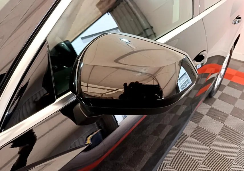 Rétroviseur côté gauche noir brillant de l'Audi Q3 Sportback 35 TFSI 2021 avec carrosserie noire vue en gros plan.