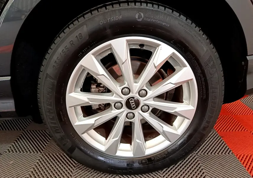 Gros plan sur la roue avant droite noire d'un Audi Q3 Sportback 35 TFSI 150 MHEV avec jante argentée à multiples branches