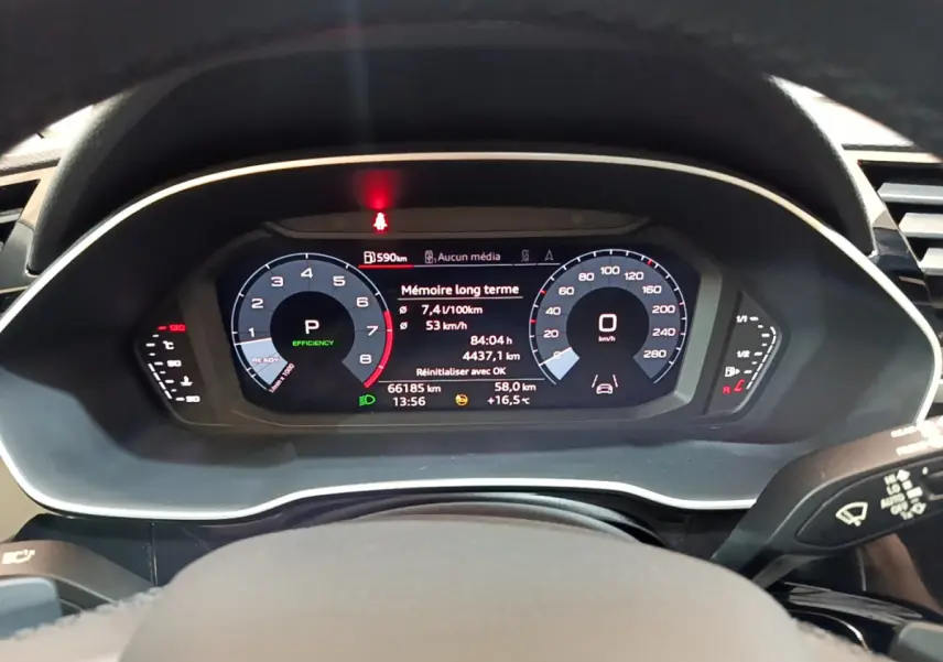 Tableau de bord numérique de l'Audi Q3 Sportback noir, affichant vitesse, consommation et informations de conduite.