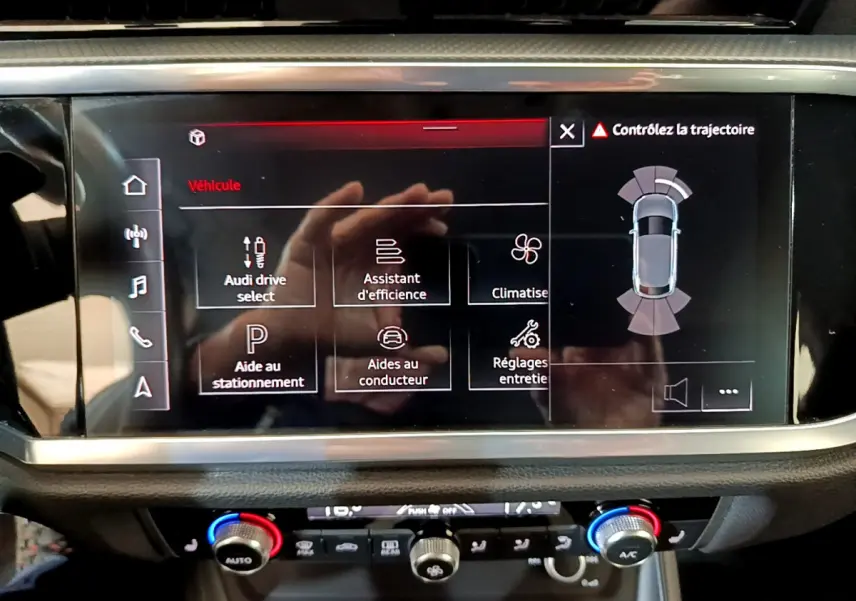 Écran tactile central de l'Audi Q3 Sportback noir 2021 affichant les aides à la conduite et la climatisation.