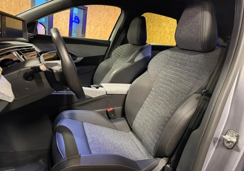 Vue intérieure côté conducteur du Peugeot 3008 1.2 Hybrid 136 Allure gris, sièges tissu et cuir gris foncé.